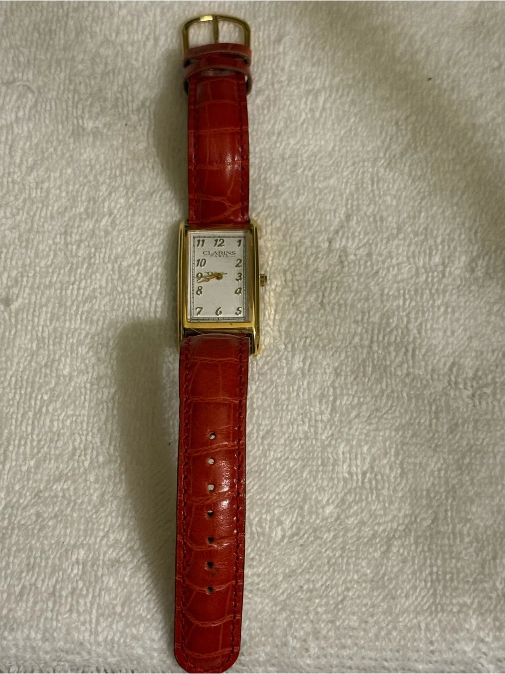 Clarins Gold-Tone Rectangular Watch with Red Strap and White Dial
